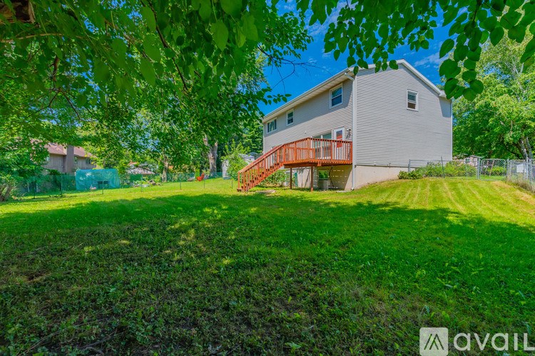 A house with a red staircase is surrounded by greenery.