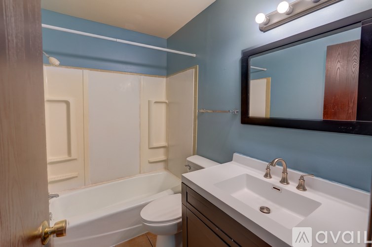 A bathroom with a blue wall and a white sink.