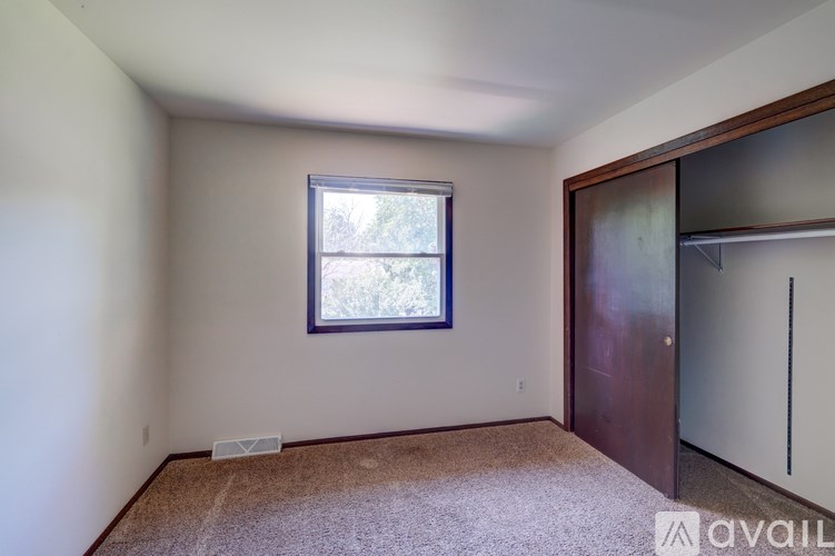 A room with a window and a door is available for rent.