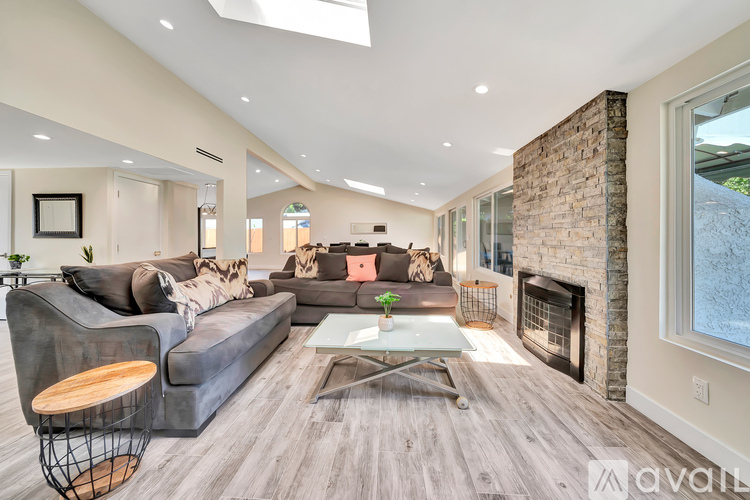 A modern living room with a grey sofa and a fireplace.