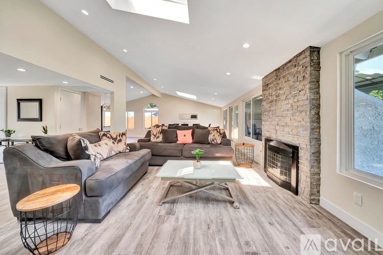 A modern living room with a grey sofa and a fireplace.