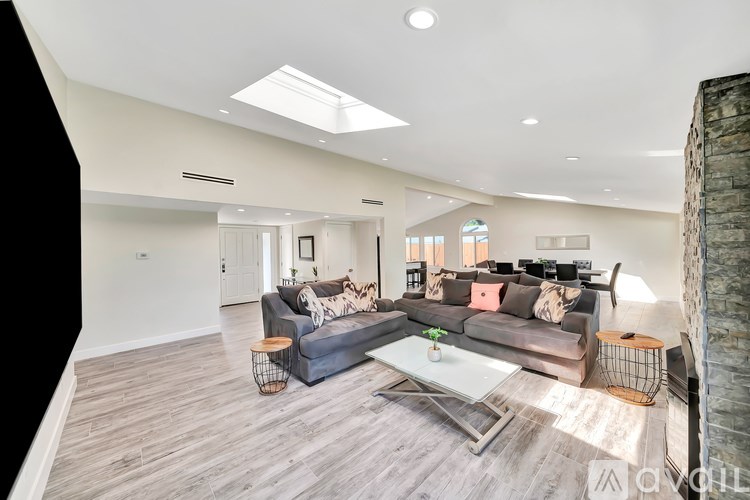 A spacious living room with a grey sofa and a coffee table.