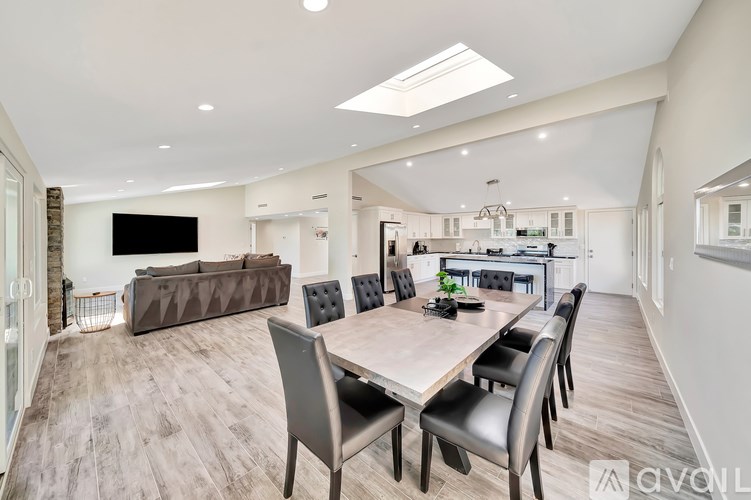 A spacious dining area with a long table and chairs.