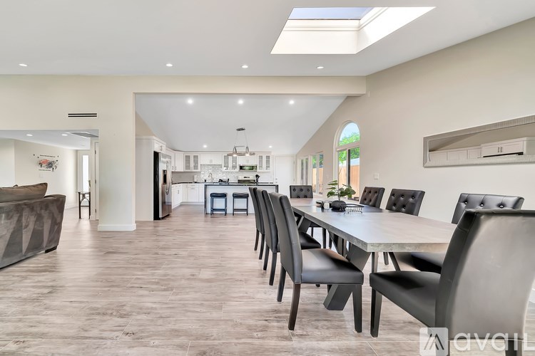 A modern dining room with a long table and chairs.
