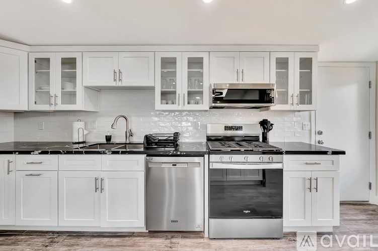 A modern kitchen with white cabinets and stainless steel appliances.