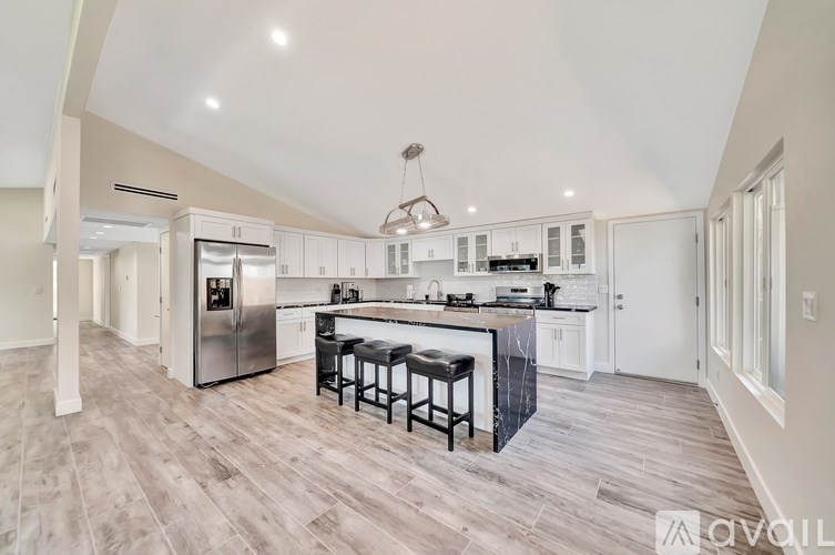 A modern kitchen with a center island and stools.