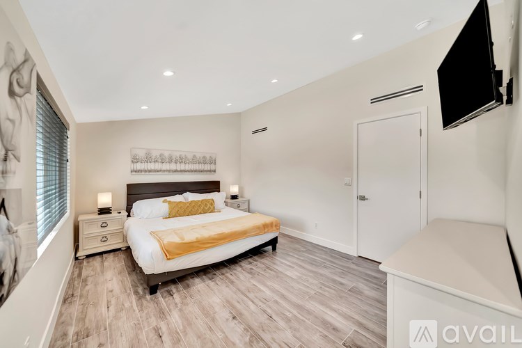 A bedroom with a bed, nightstand, and a television.