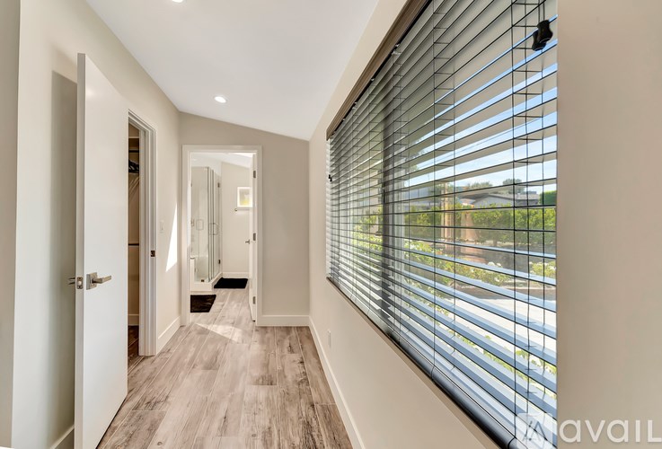 A hallway with a mirror and wooden floors.