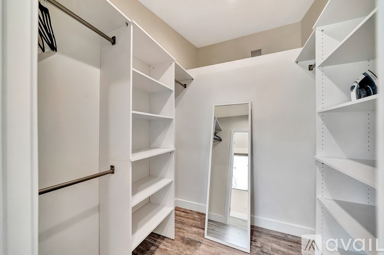 A white closet with shelves and a mirror.