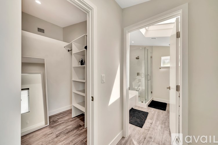 A hallway with a white door and a mirror on the wall.