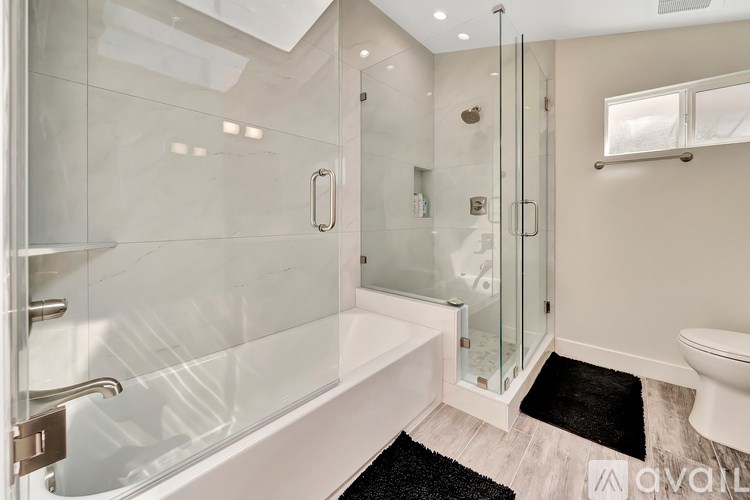 A modern bathroom with a walk-in shower and a toilet.