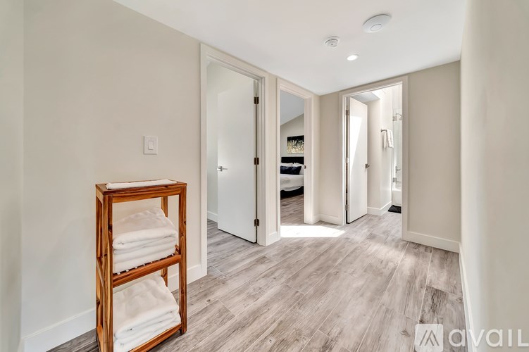 A room with a white door and a wooden towel rack.