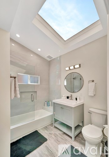 A bathroom with a skylight and a white toilet.