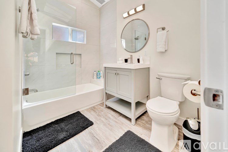 A white bathroom with a towel hanging on the wall.