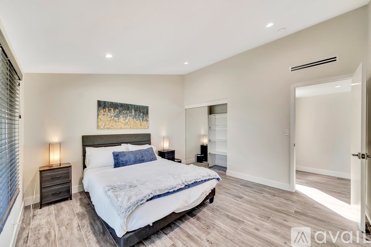A bedroom with a large bed and a painting on the wall.