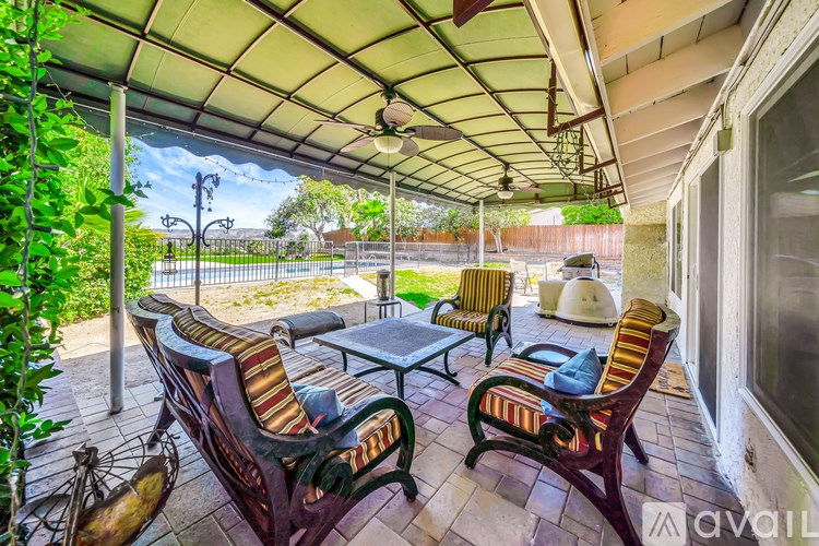 A patio with a table and chairs under a roof.