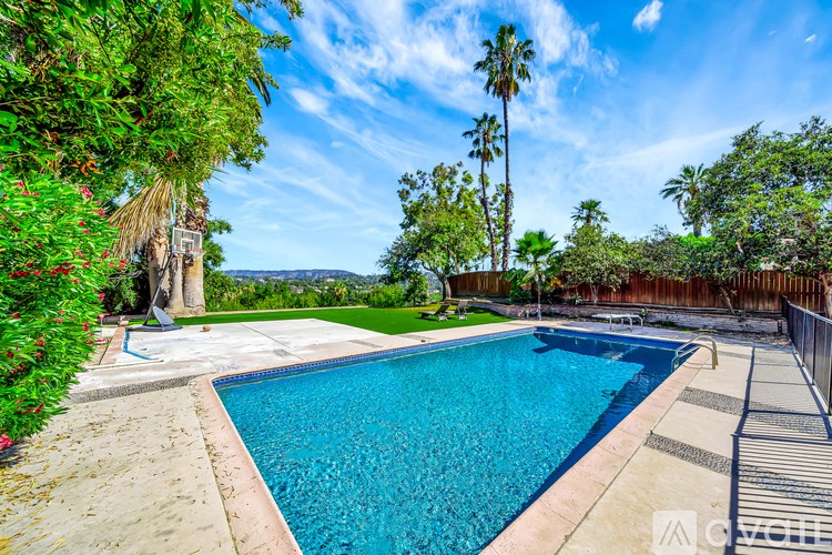 A pool surrounded by a fence and trees.