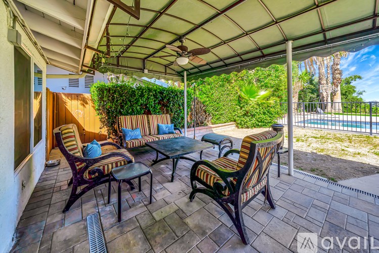A patio with a table and chairs under a roof.