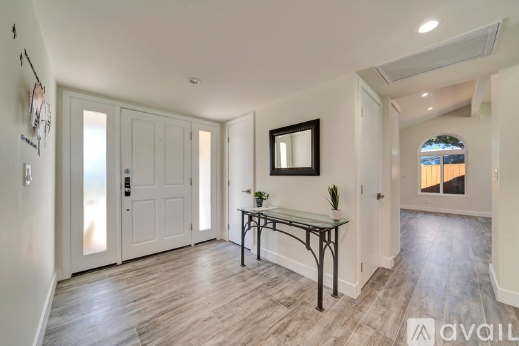 A room with a table and chairs and a mirror on the wall.