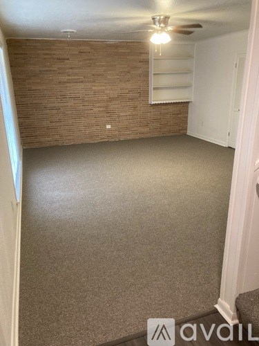 A room with a brick wall and a carpeted floor.