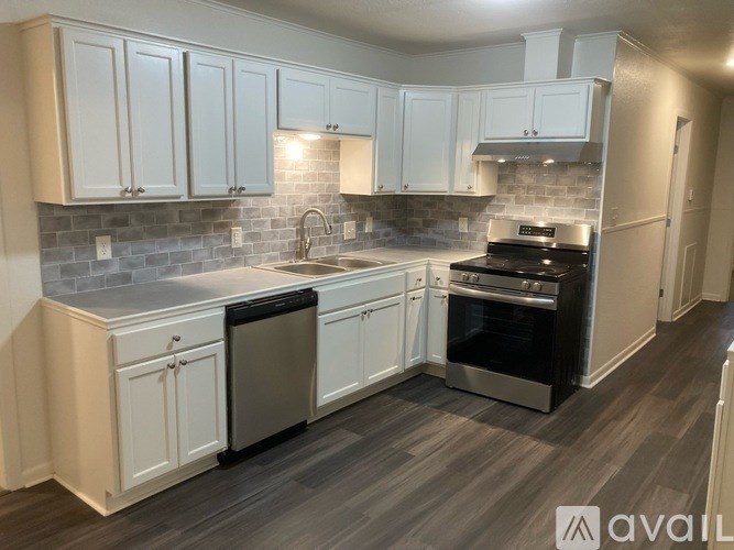 A kitchen with white cabinets and a grey countertop.