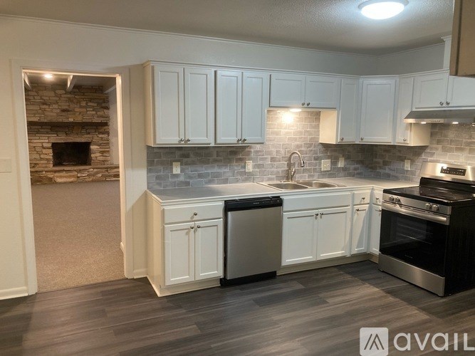 A kitchen with white cabinets and a brick fireplace.