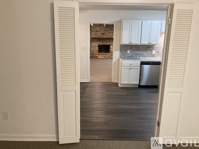A kitchen with white cabinets and a brick fireplace.