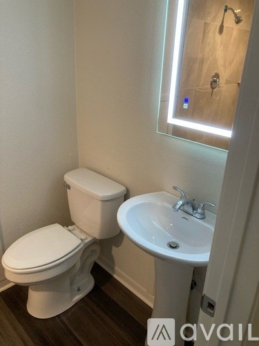 A white toilet and sink in a small bathroom.