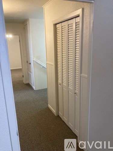 A hallway with a closed white door on the right.