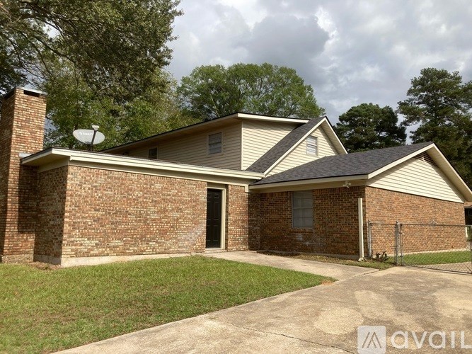 A house with a brick wall and a satellite dish on the roof.