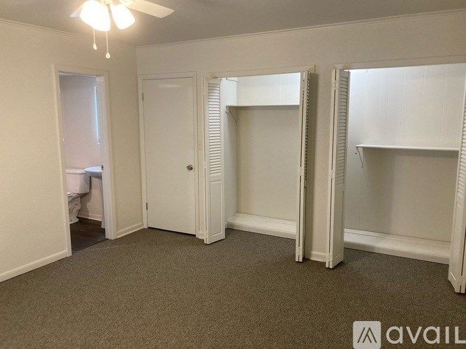 A room with a carpeted floor and a ceiling fan.
