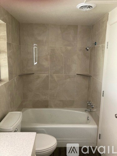 A bathroom with a toilet, tub, and shower.