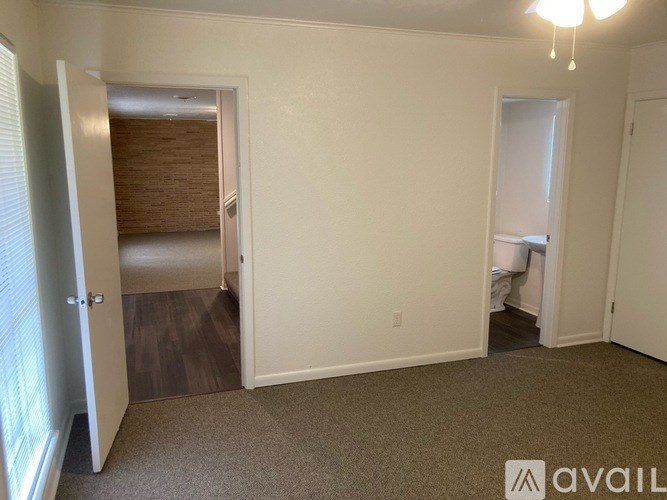 A room with a carpeted floor and a door leading to a hallway.