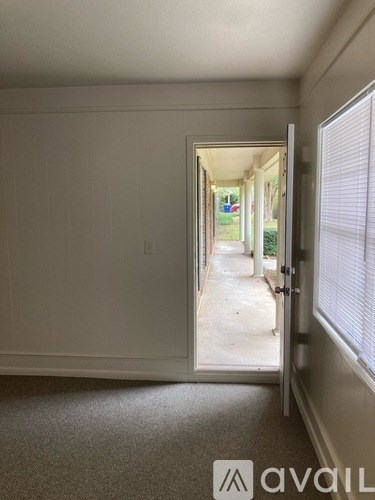A hallway with a door open to a patio.