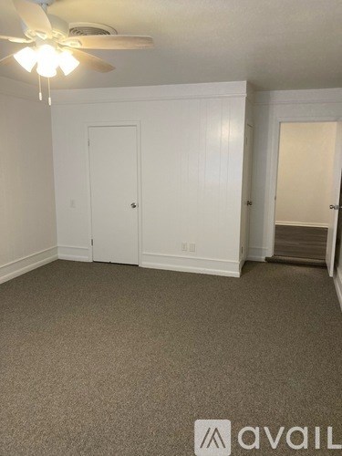 A room with a ceiling fan and two doors.