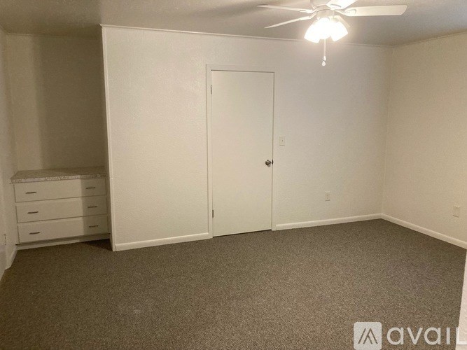 A room with a ceiling fan and a door.