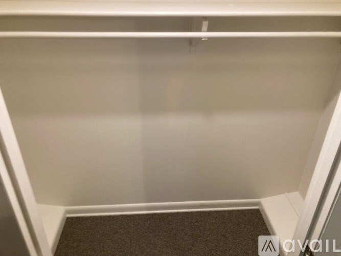 A small, empty room with a brown carpet at the bottom.