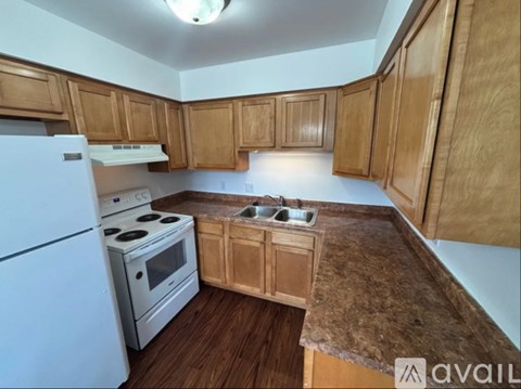 A kitchen with wooden cabinets and a white refrigerator.