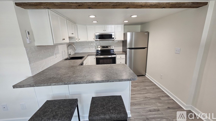A kitchen with a granite countertop and stainless steel appliances.