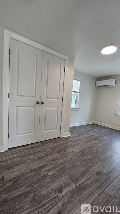 A room with a wooden floor and a white door.
