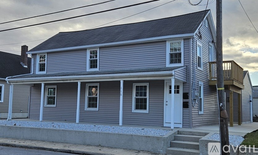 A two-story house with a grey exterior and white trim.