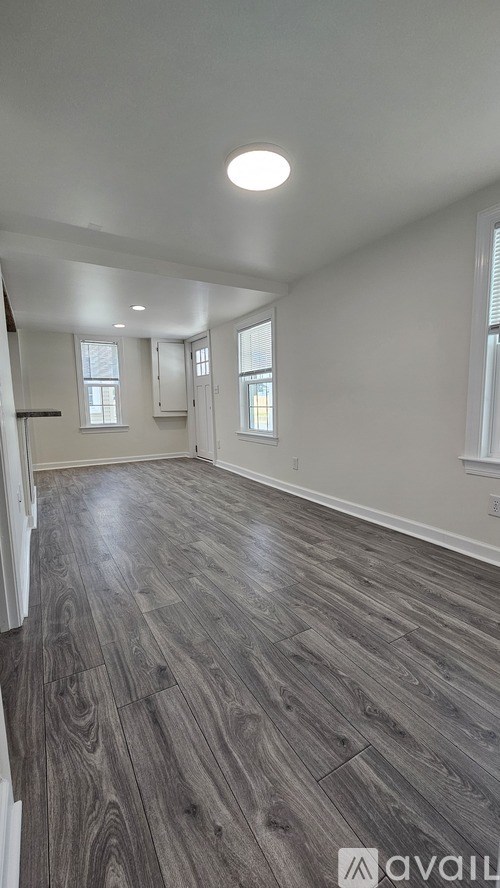 A room with wooden flooring and white walls.