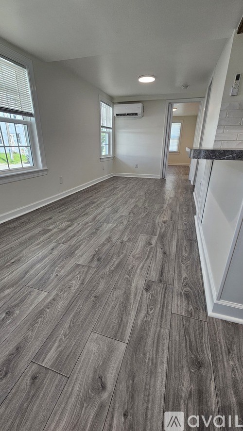 A room with wood flooring and a window.