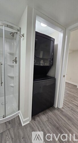 A black microwave is installed in a kitchen with a glass door.