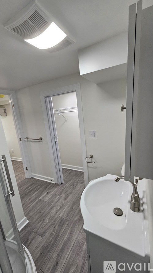 A bathroom with a white sink and a white door.