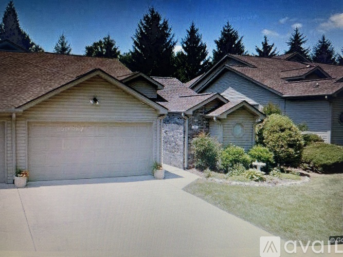 A house with a garage and a driveway in front of it.