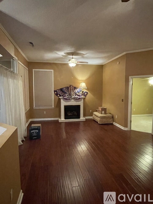 A living room with a fireplace and wooden floors.