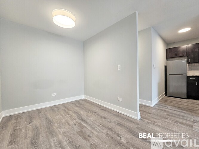 A room with a grey floor and a white wall with a light on.