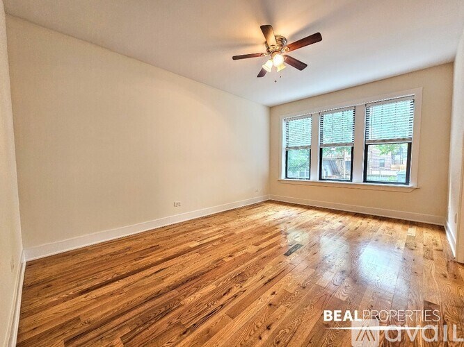 A room with wooden flooring and a ceiling fan.
