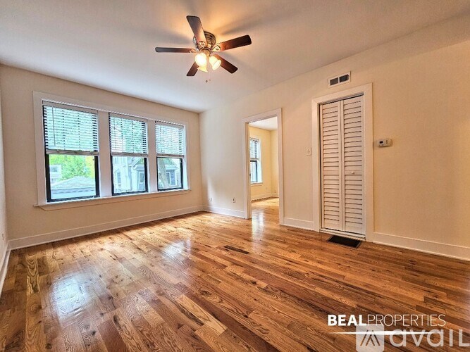 A room with wooden flooring and a ceiling fan.